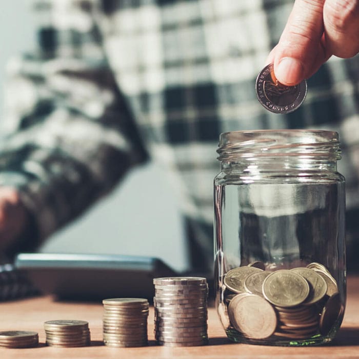Man dropping coins into a jar